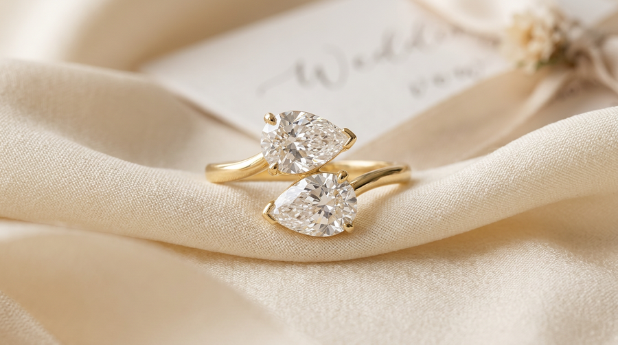 Toi et moi engagement ring with two pear lab grown diamonds in 14k yellow gold bypass setting on cream silk